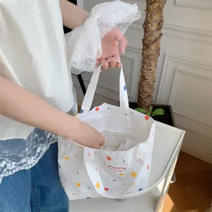 Borsa shopper in tela bianca con stampa a pois colorati, pratica borsa casual elegante.