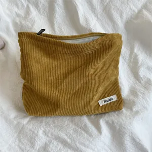 Corduroy makeup bag detail, yellow portable cosmetic pouch with zipper closure, daily storage.