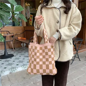 Knitted checkerboard tote bag in autumn cafe scene, soft knit handbag detail view.