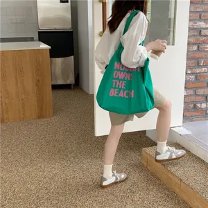 Green canvas shoulder bag detail, large capacity tote bag with pink letter print for daily use.