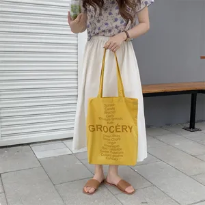 Yellow canvas tote bag with grocery letter print, casual shoulder bag for women daily use.