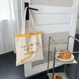 Large capacity canvas shoulder bag with inspirational letter print, stylish casual tote design.