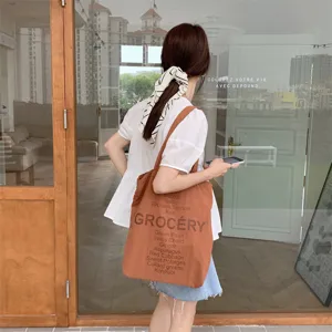 Casual brown canvas tote bag for women with grocery letters print and shoulder strap style.