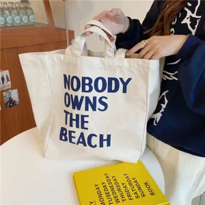 Canvas tote bag detail, beige large capacity shoulder shopping bag with blue letters.