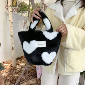 Flauschige schwarz-weiße Herz Plüschhandtasche Detail, süße Tragetasche für Studenten.