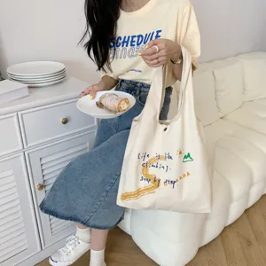 Large capacity canvas shoulder bag with inspirational letter print for casual daily use and travel.