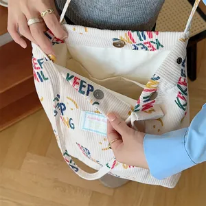 Detailed view of the beige corduroy tote bag interior, showing quality fabric and button.
