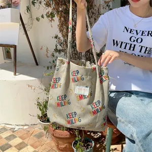 Corduroy large tote bag featuring colorful smiling text print, ideal for daily casual commute.