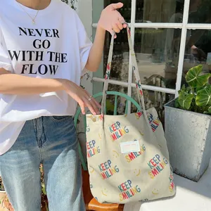 Detail view of the stylish corduroy canvas tote bag with colorful letters and large capacity.