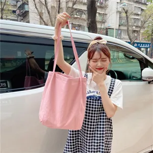 Pink canvas tote bag detail, casual minimalist daily handbag with slim shoulder strap for women.