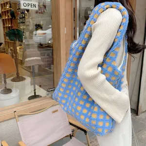 Detailed view of fluffy blue and yellow checkered tote bag worn on shoulder for daily commute.