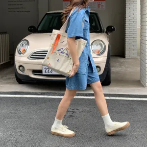 Grand sac cabas en toile sac à épaule avec broderie élégante et sangle de couleur contrastée.