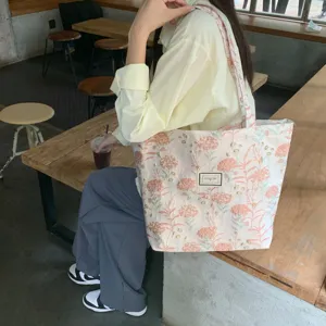 Nahaufnahme der vintage rosa floralen Jacquard Tragetasche am Modell im gemütlichen Café.