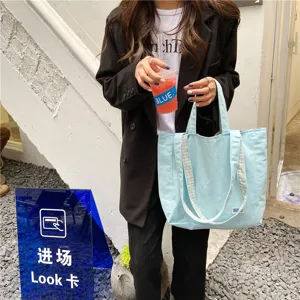 Casual light blue canvas tote bag for women, stylish student shoulder bag with plaid straps.