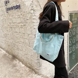Casual canvas shoulder bag for women, stylish blue tote bag with plaid handles for daily use.