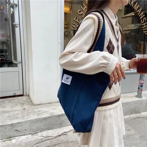 Vue détaillée d'un sac cabas décontracté en toile bleue, style vintage minimaliste quotidien.