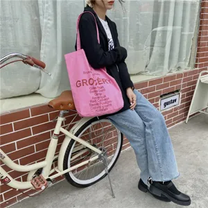 Pink canvas tote bag detail view, casual shoulder shopping bag with grocery letter print for women.