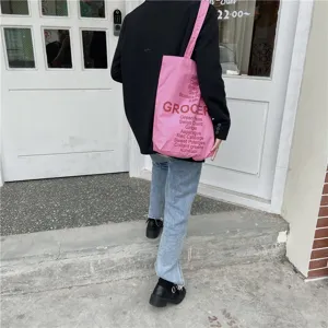 Pink canvas tote bag detail, featuring letter and vegetable print for casual everyday style.