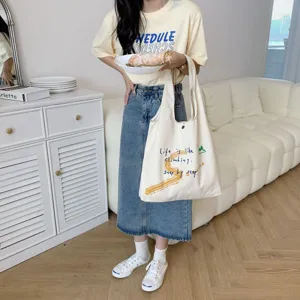 Casual large capacity canvas shoulder bag with artistic text print, stylish daily accessory.