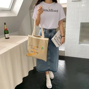 Large capacity canvas shoulder bag with inspirational letter print for casual daily use.