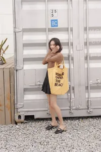 Detail view of canvas tote bag featuring slogan text, styled in industrial outdoor setting.