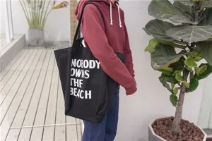 Casual black canvas tote bag for women with white letter print, large capacity shoulder bag.