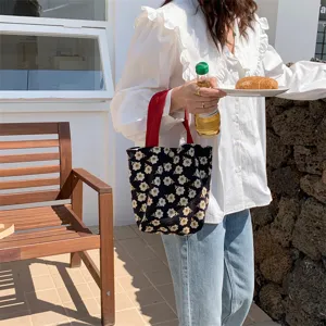 Floral corduroy tote bag for lunch bento box, cute daisy print handbag with red handles.