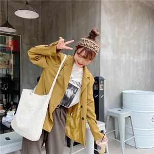 Close-up detail shot of the Japanese style daisy canvas tote bag worn by model, casual style.