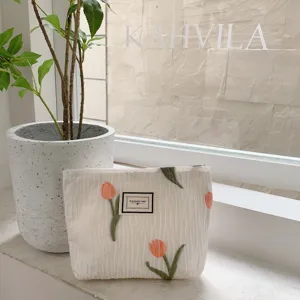 White canvas cosmetic pouch featuring cute tulip embroidery for daily storage and travel use.