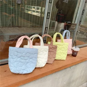 Quilted floral tote bag in pastel colors, featuring soft fabric and spacious design for daily use.