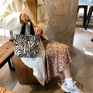 Black and white zebra print canvas tote bag, portable lunch handbag, casual daily lifestyle detail.