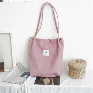 Close up view of a pink corduroy shoulder tote bag detail showing fabric texture and design.