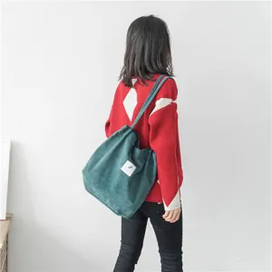 Corduroy shoulder bag detail shot, showing large capacity and soft fabric texture in daily use.