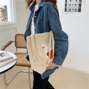 Detailed shot of the cute corduroy shoulder bag featuring rabbit embroidery and soft fabric texture.