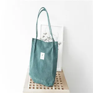 Close-up detail of the vintage green corduroy tote bag featuring comfortable shoulder straps.
