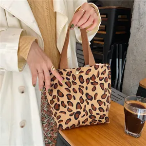 Detailed view of the leopard print corduroy tote bag featuring sturdy brown straps and snap closure.