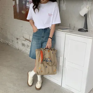 Sac cabas en toile avec broderie colorée et sangle contrastée, idéal pour un usage quotidien.