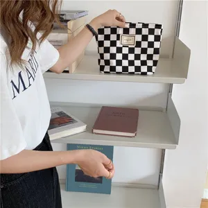 Détail de pochette en toile à carreaux noir et blanc, scène de sac à main quotidien.