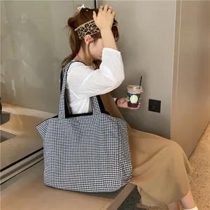 Detailed view of the casual black and white plaid tote bag in use by model, large capacity.