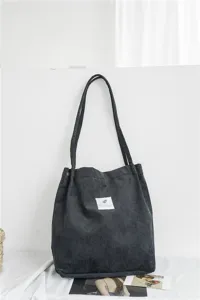 Detailed view of a dark grey corduroy tote bag, featuring spacious capacity and casual style.