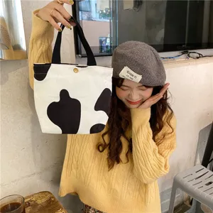 Cute cow print corduroy lunch tote bag, casual daily handbag with sturdy black handles.