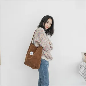 Corduroy tote bag detail shot showing the soft brown fabric and practical shoulder strap design.
