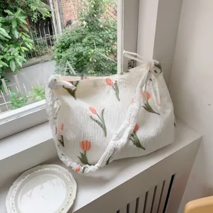 Detailed view of white pleated canvas tote bag featuring lovely orange tulip prints.