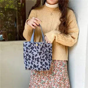 Detail shot of grey leopard print corduroy tote handbag, casual hand-held lifestyle design.
