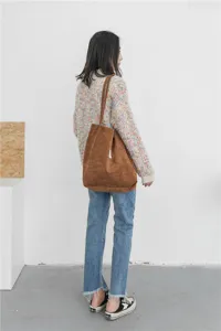 Brown corduroy tote bag displayed by model, casual large capacity shoulder bag for use.