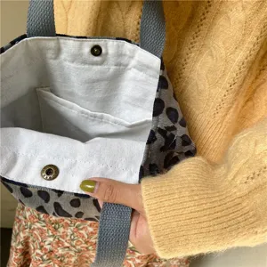 Detail view of vintage corduroy lunch tote bag featuring interior pockets and snap closure.