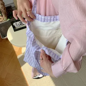 Detailed view of purple checkered canvas tote bag interior, showing lining and zipper pocket.