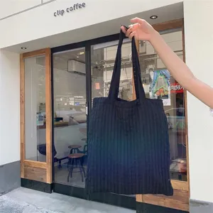 Black quilted tote bag detail shot, casual shoulder handbag for daily use in street style fashion.