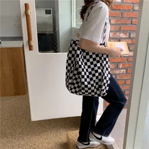 Détail du sac cabas en toile à carreaux noir et blanc, sac porté épaule décontracté.