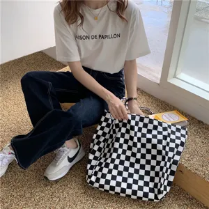Détail de sac cabas en toile à carreaux noir et blanc, grand sac bandoulière décontracté.